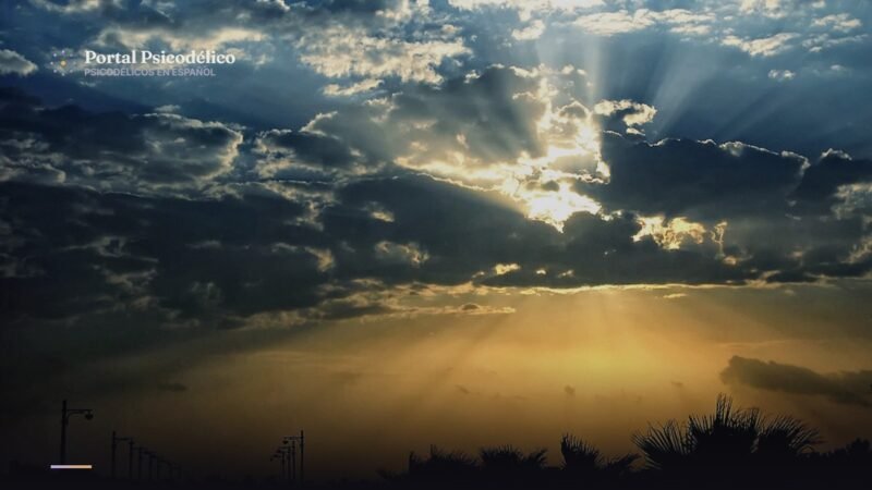 Amanecer con rayos de luz entre nubes, símbolo de apoyo en crisis psicodélicas